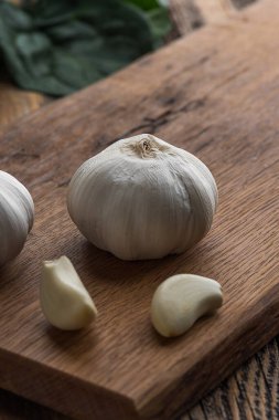 Ahşap arka planda sarımsak doğrama tahtası.