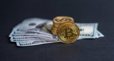 Dolar banknotu arka planına sahip Bitcoin.