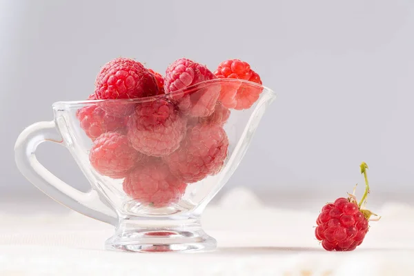 Ripe sweet raspberries in bowl on white table. Close up, top view, high resolution product. Fresh raspberry in a transparent glass plate. — Stock Photo, Image