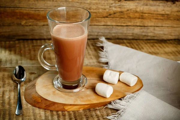 Café con leche aislada sobre fondo de madera con cuchara y zephyr. Café con leche. Latte caliente sabroso con leche. Café, leche y azúcar. Café con leche, cafetera, granos de café, imagen de tono oscuro — Foto de Stock