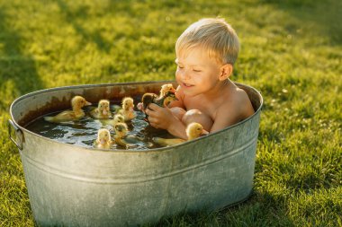 Küçük şirin çocuk oyun ile parlak bir arka elinde ördek yavrusu