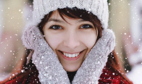 Retrato de mulher atraente branca sorrindo feliz com neve. Feliz menina sorridente. Menina com mittend brincar com neve e rir. Bom humor e bom conceito de vida. Sorriso saudável branco . — Fotografia de Stock