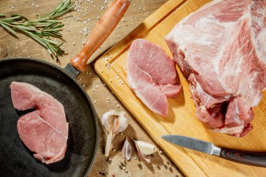 Çiğ domuz biftek bir tavada bir mutfak masasında