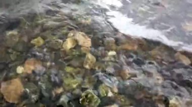 Kayalık bir kıyıda akan nehir dalgası