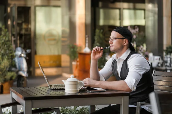 Hombre de negocios que trabaja con el ordenador portátil en la cafetería al aire libre — Foto de Stock