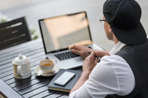 Freelancer trabajando con laptop en una cafetería al aire libre — Foto de Stock