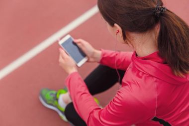 Cep telefonu kullanarak ve koşu sonra dinlenme sırasında müzik kadın runner