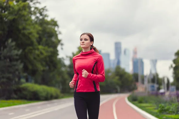 Young fitness woman running in the city park — Stock Photo, Image