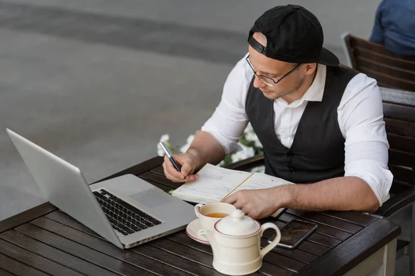 Hombre de negocios trabajando y tomando notas al aire libre — Foto de Stock
