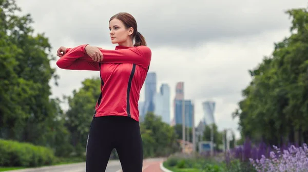 Joven atleta estira los brazos antes de correr al aire libre Imágenes de stock libres de derechos