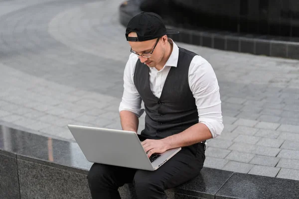 Guapo joven programador trabajando con el ordenador portátil al aire libre . — Foto de Stock