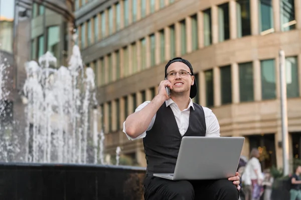 Feliz freelancer exitoso trabajando con portátil y teléfono al aire libre Fotos de stock