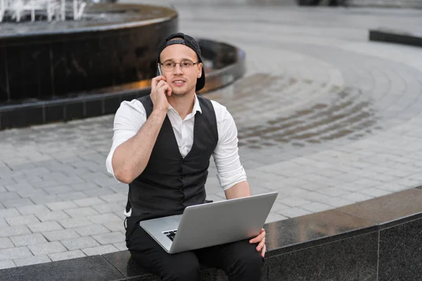 Feliz freelancer exitoso trabajando con portátil y teléfono al aire libre Imagen de stock