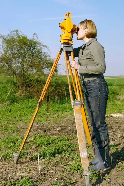 Kobiece geodeta wykonuje geodetic survey — Zdjęcie stockowe