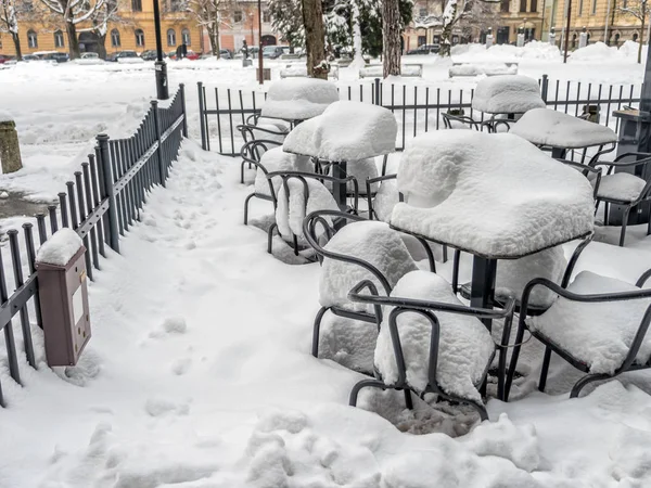 Outdoors restaurant chairs and tables covered with thick snow cover — Stock Photo, Image
