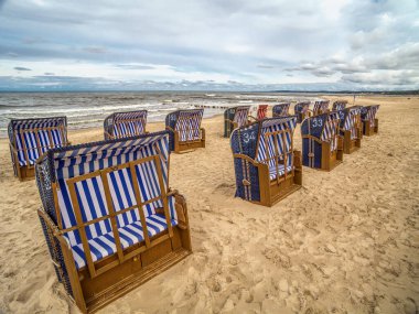 Ustka tatil köyü, Baltık Denizi, Polonya 'da kumlu sahilde boş hasır plaj sandalyeleri Yazın bittiğine dair açık bir işaret