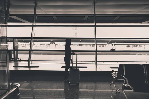 乗客が空港ターミナルに 黒と白のトーンでゲート遅延便を待っている荷物を運ぶ — ストック写真