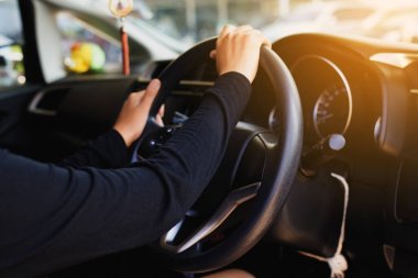 Eller kadın holding direksiyon simidi ve otomatik vites üzerinde bir araba