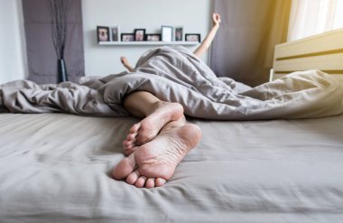 Yalınayak, ayak ve sabah uyanma sonra streç hafifçe yatağa yakın