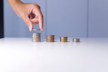 Para sikke yığını ve büyüyen bir masaya koyarak el para kavramı kaydetme