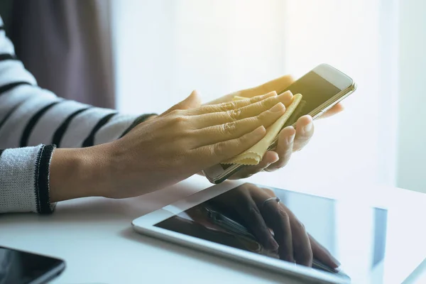 Akıllı telefon ekranında mikrofiber bezle temizlik el kadın