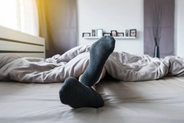 Närbild Fot Med Strumpor Fötter Och Sträcka Lättjefullt Sängen Efter — Stockfoto