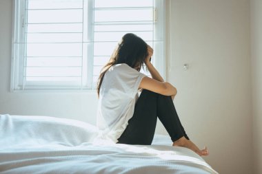 Asyalı kadın sabah uyandıktan sonra yatakta bir baş ağrısı olabilir
