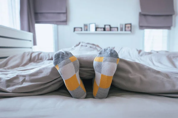 신발맨발로 맨발로 잠에서 깨어난 침대에서 스트레칭하십시오 — 스톡 사진