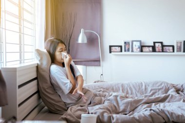 Yatakta soğuk üfleme ve burun akıntısı olan genç asyalı kadın, hasta kadın hapşırma,Sağlık Kavramı