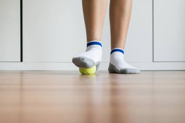 Yatak odasında ayağına tenis topuyla kadın masajı, ayak tabanı masajı, ayak bileği iltihabı.