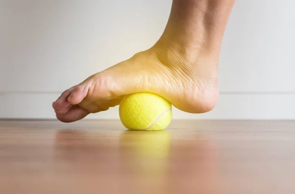 Yatak odasında ayağına tenis topuyla kadın masajı, ayak tabanı masajı, ayak bileği iltihabı.