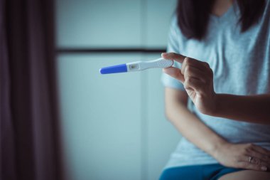 Yatak odasında test yaptıktan sonra kadın ellerini tutup gebelik testi yaptır.