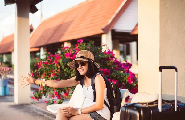 Beautiful asian woman tourist sitting with luggage and waiting train at train station,Travel and vacation concept