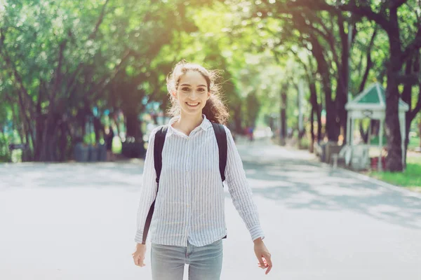 Beautiful young woman walking at public park in the morning,Happy and smiling,Relaxing time,Positive thinking