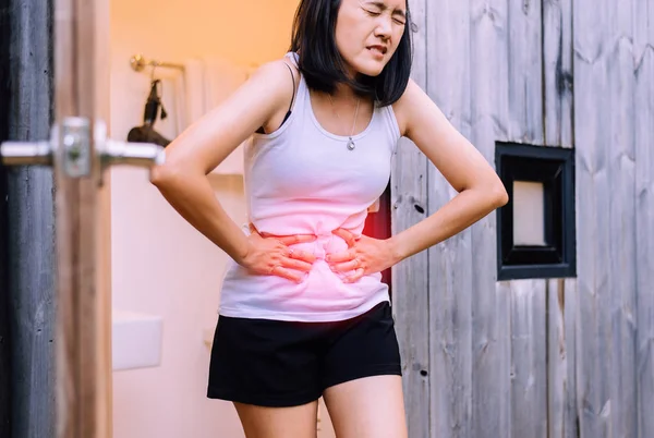 自宅で痛みを伴う腹痛を持つ女性 腹痛に苦しむ女性 期間のけいれん 手が腹を絞る — ストック写真