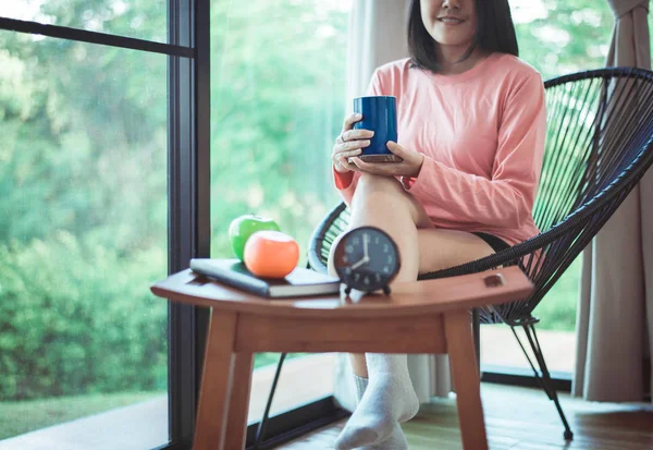 Beautiful asian woman drinking hot coffee after wake up in living room,Relaxing time,Happy and smiling