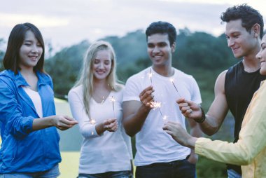 Çeşitlilik en iyi arkadaş ellerinin maytap tutması ve birlikte doğanın tadını çıkarması, mutlu yıllar konsepti