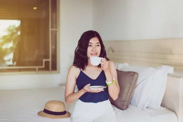 Beautiful asian woman drinking hot coffee in bedroom,Relax time,Happy and smiling,Healthy and lifestyle concept