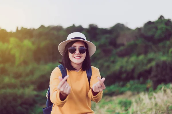 Happy asian woman standing and showing mini heart shape at sunset,Free time,Positive thinking