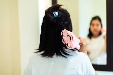 Güzel bir kadın elektrikli saç maşası kullanıyor, saçları düzleştiriyor, düzleştiriyor, kapatıyor.