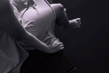 Depresyondaki kadın ahşap köprüde tek başına oturuyor, akıl sağlığı bozuk, dünya intiharını önleme günü konsepti, yakın plan, siyah beyaz tonu.