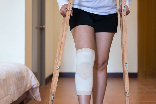 Woman patient using crutches and broken legs for walking in bedroom,Close up