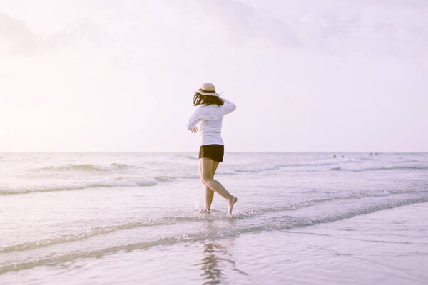 Веселая молодая красивая женщина, гуляющая по пляжу заката, расслабляющее время, позитивное мышление
