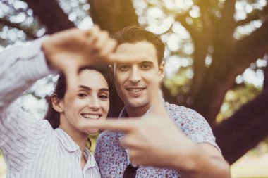Birbirine aşık çiftler elleriyle şekil değiştirip kameralara bakıyorlar, birlikte mutlu anlar yaşıyorlar.