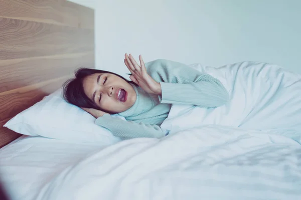女性Yawningオン彼女のベッドルームと疲れて眠い 症状と眠気 — ストック写真