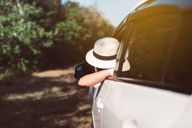 Mutlu Asyalı kadın yeni arabasında yolda oturuyor, rahat ve boş zaman, mutlu ve gülümsüyor.