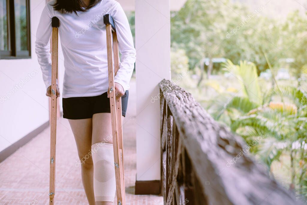 Woman using crutches and broken legs for walking outdoor