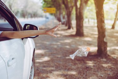 Kadın eli plastik şişe çöplerini yola atıyor, Çevre ve kirlilik kampanyası konsepti