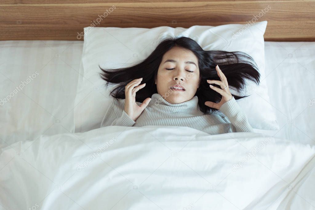 Bad dream or Nightmare,Asian woman with scared and panic while lying down under the blanket in bedroom