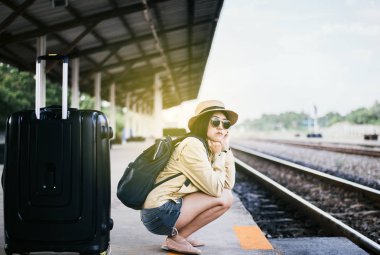 Hipster Asyalı kadın turist tren istasyonunda, seyahat ve tatil konseptinde bekliyor.